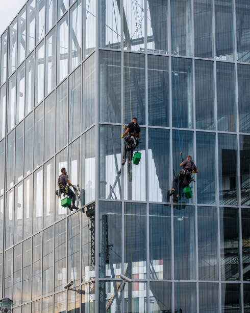 industrial climbing or Rope access window cleaning on a facade of an office building stock photo
