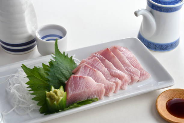 istock Raw Yellowtail fish or Hamachi sashimi on white plate with soy sauce and Japanese Sake-Japanese food 1424521981