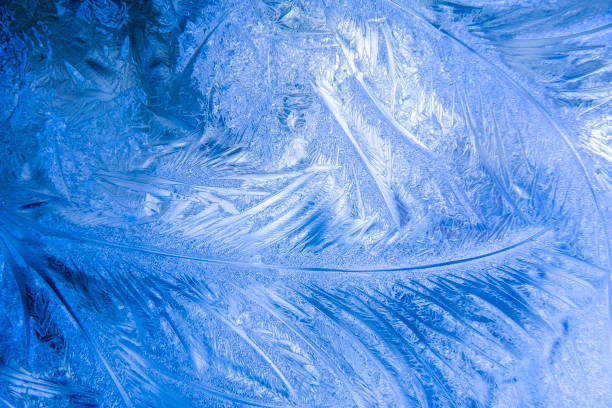 istock Christmas blue background with frozen pattern on window. 1424526920
