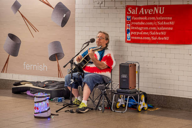 London, UK - May 02, 2011: A man plays guitar in South Kensington station in the evening. Underground tubes sometimes may host for street musicians.