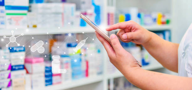 pharmacien utilisant un téléphone intelligent mobile pour la barre de recherche affichée dans les étagères des pharmacies en arrière-plan. - doctor digital display digital tablet healthcare and medicine photos et images de collection
