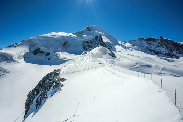 The Allalin ski area is one of the longest ski runs in the Alps, that can be reached by a cable car and the mountain train. Visible from a distance is the Allalinhorn mountain, that lies above Saas-Fee in Switzerland.