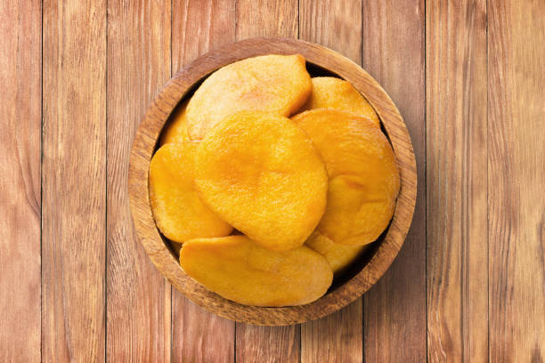ドライフルーツ、木製のテーブルの背景にボウルに桃を半分、上面図。有機ベジタリアン料理。 - fruit vegetable fruit bowl peaches ストックフォトと画像