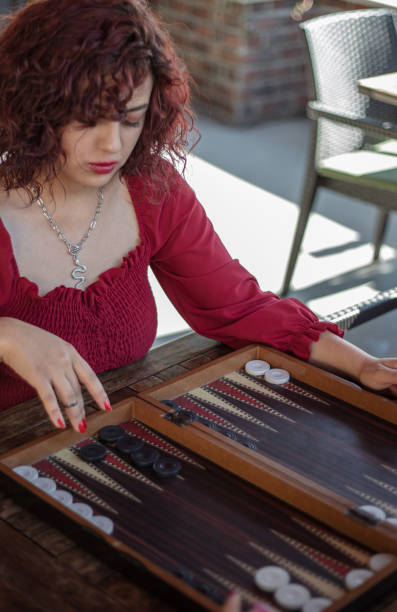 istock A woman in red shirt playing backgammon. 1424561294