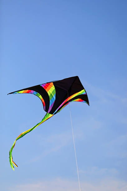 istock black kite with multicolored stripes flies in the sky attached to the string 1424577052
