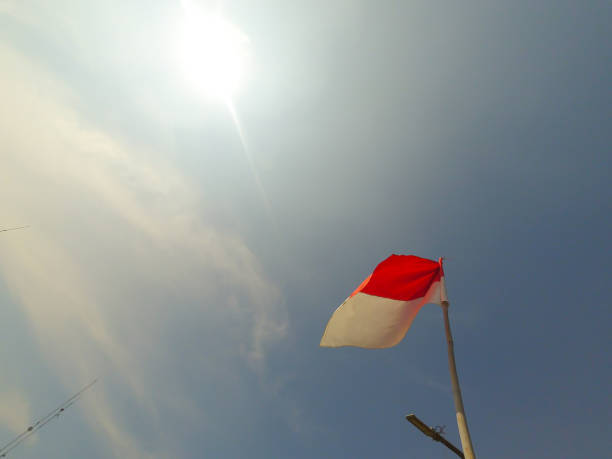 istock Red and white flag flying on the flagpole - Stock photo 1424578607