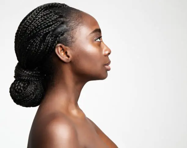 Photo of African Braids Hairstyle. Afro Hair Braided. Beauty Woman Face Profile. Dark Skin Care and Cosmetology. Fashion Model Side view Portrait isolated White