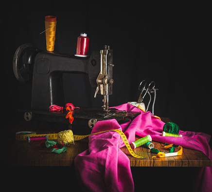 old sewing machine, along with scraps of colored fabric and a multitude of balls of thread of various colors.