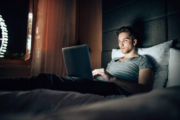 istock man working in the bed at late night 1424583318