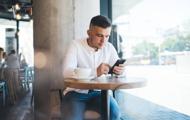 istock Thoughtful male browsing mobile phone in cafe 1424583349