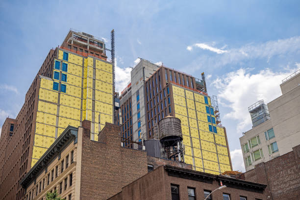 Manhattan, New York, NY, USA - July 16th 2022:  Yellow insulation material on the façade old brownstone high rise buildings at 8th Avenue