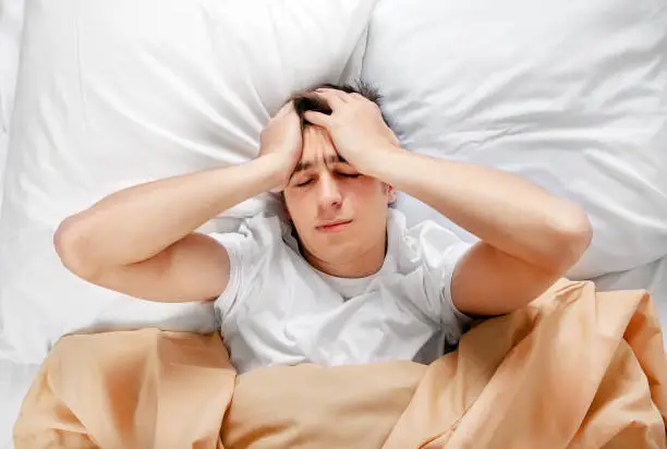 Young Man feel Headache in the Bed at the Home