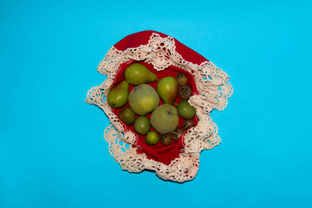 früchte auf einem rot von zerknitterter tischdecke, kreatives herbstdesign auf blauem hintergrund - lucy pearson stock-fotos und bilder