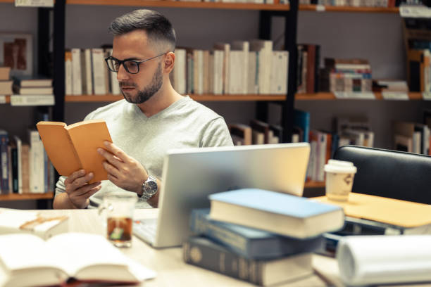 istock A male student studying in the campus library .He reads a book. 1424591733