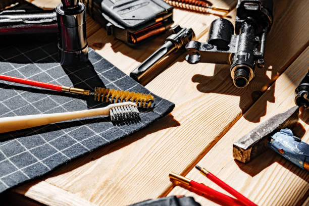 istock Black disassembled shotgun and cleaning tools on wooden table . 1424593628