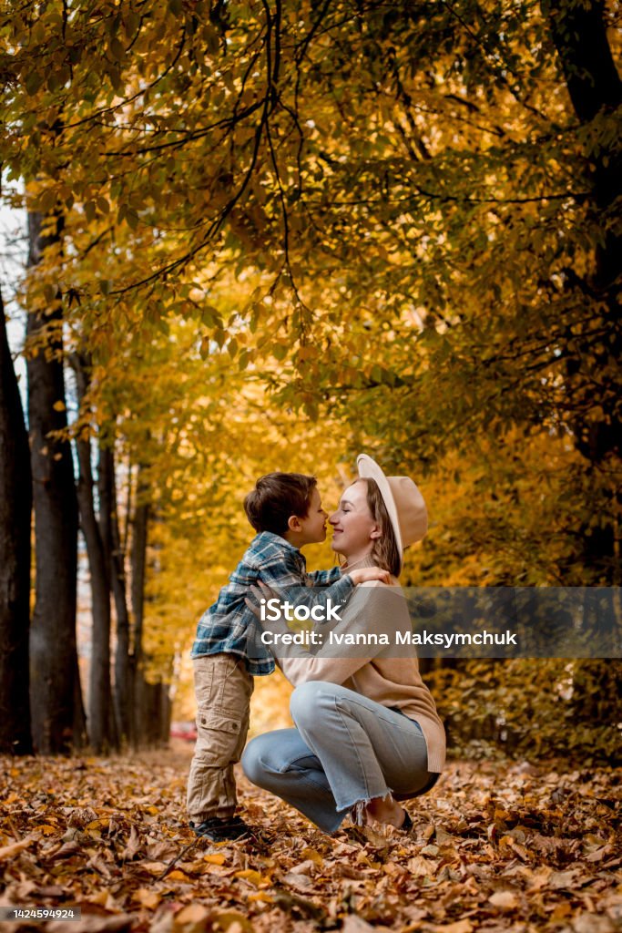 Mother and her little son are touching their noses and smiling. The family is dressed in autumn clothes. Happy together Mother and her little son are touching their noses and smiling. The family is dressed in autumn clothes. Happy together. 4-5 Years Stock Photo