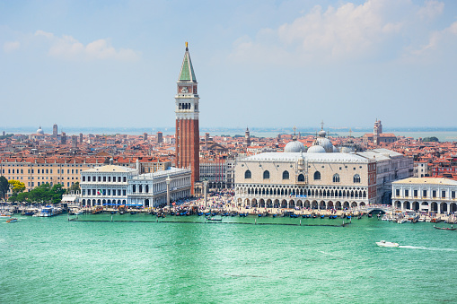 Venice - July, 25, 2020: landscape with lighthouse, saint marks campanile, motorboat and grand canal in Venice, Italy.