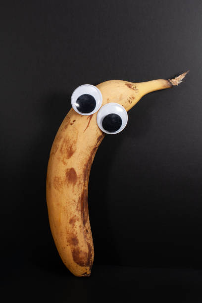 istock banana with eyes isolated on black background 1424596854