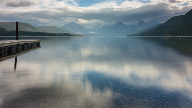 reflexos do lago mcdonald ao nascer do sol - montana sunrise mountain mountain range - fotografias e filmes do acervo