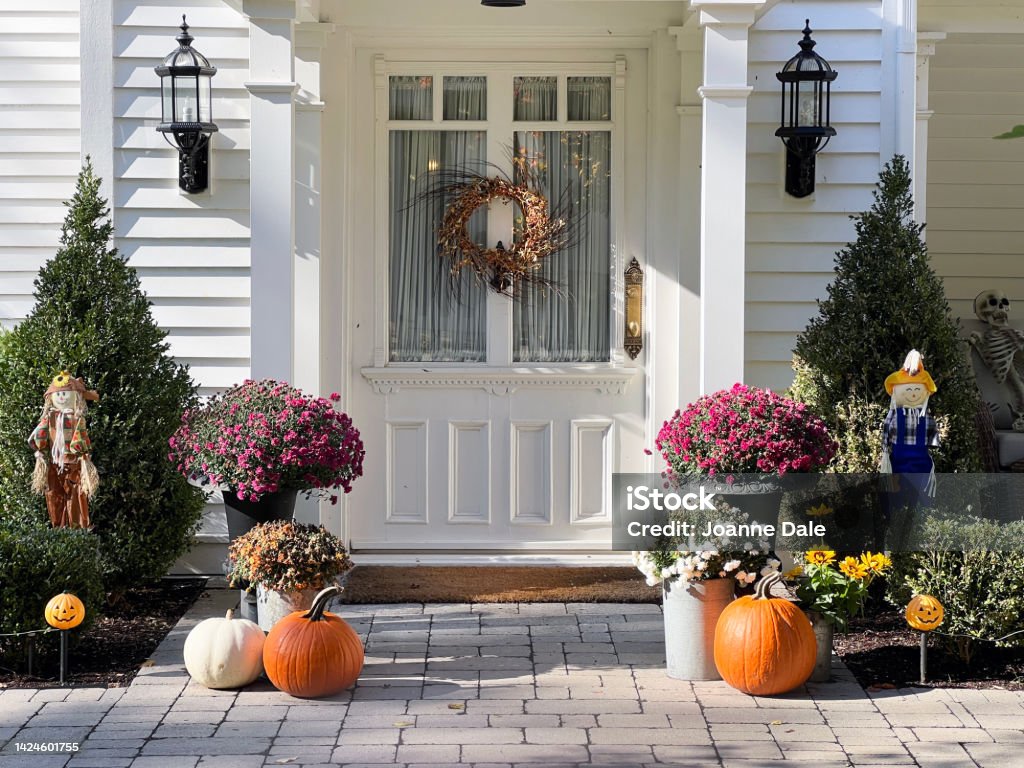Residential autumn landscaping decor. Pumpkins, gourds and mum decorate the home entrance. Colourful pumpkins, gourds and mums create a luxury autumn halloween and thanksgiving landscaping decor. Autumn Stock Photo