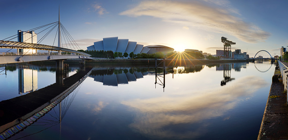 Glasgow Cityscape at sunrise, skyline panorama with reflecion in river with sun, Scotland - UK