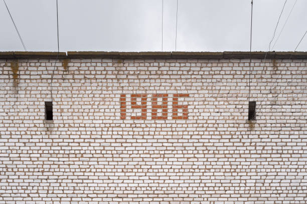 надпись 1986 года выложена из кирпича на стене старого советского здания. - 1986 стоковые фото и изображения