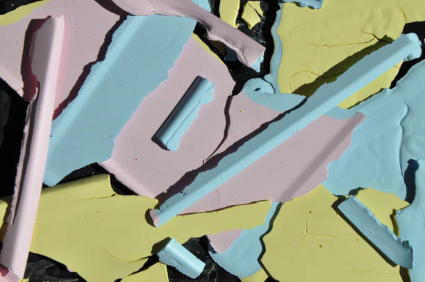 istock Dried pastel paint (pink, blue, yellow)in casting shadows in sunlight against a dark backgraound 1424609548