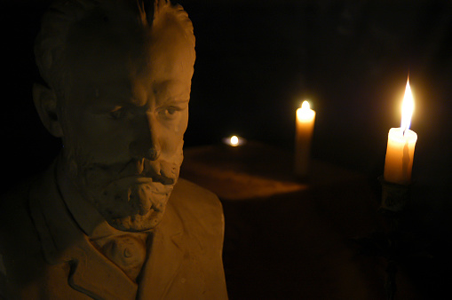 Gypsum figure of the composer Tchaikovsky in the studio with lighting and filters effect from the candle cinematographic effect