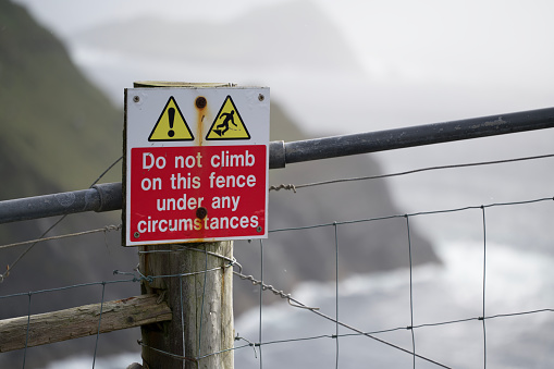 Sign near tall cliffs that reads do not climb this fend under any circumstances
