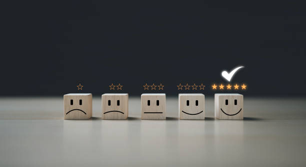 istock Questionnaire best excellent business services rating customer experience. Chooses a smiley face on wood block cube. Satisfaction survey. Give five Star good comparison. 1424617661