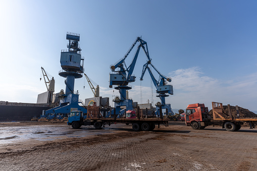 Cranes and vehicles at the port are handling timber