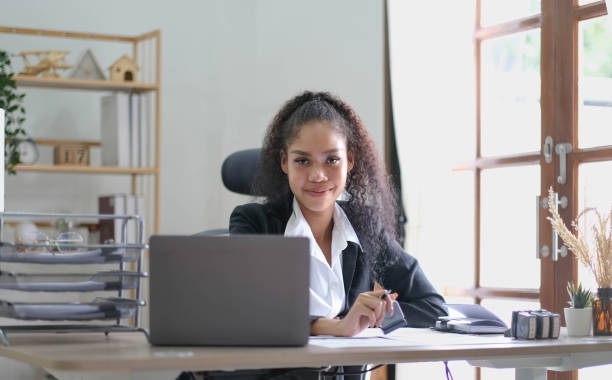 istock Creative young african american woman working on laptop in her studio,Doing accounting analysis report real estate investment data, Financial and tax systems concept. 1424619178