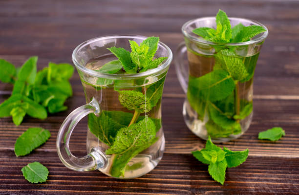 istock Mint tea. Two cups of mint tea on a dark wooden background. 1424619528