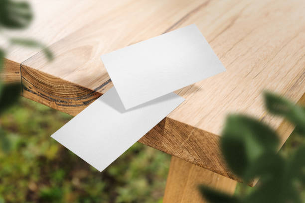 istock Clean minimal business card mockup floating on top table with leaves 1424619749