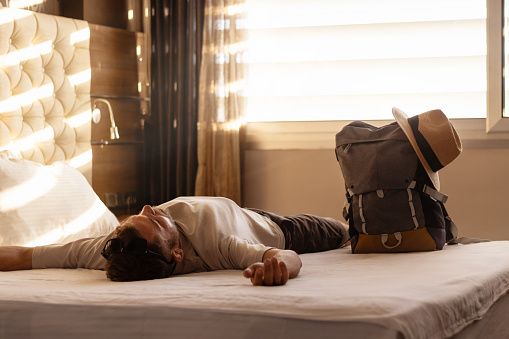 Young adult man in hotel room after check-in. Travel concept.