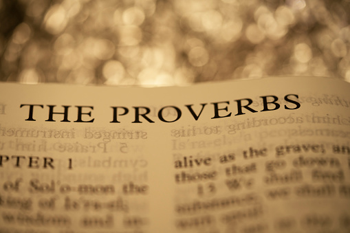 Open book of Holy Bible The PROVERBS and gold lighting bokeh for background and inspiration