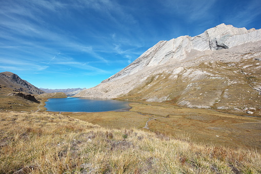 The lake is located in the Bouchouse valley 2 km south of Lake Égorgéou and 7.6 km from Échalp, the starting point for my hike.\nOn the right, the magnificent La Taillante ridge (North Peak 3197m 3185m and South Peak 3178m) with its marble benches.\n\nPhoto taken looking north