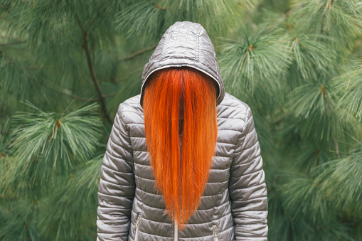 Orange color dyed hair covers female face