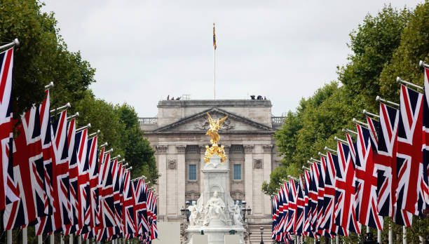 una vista di buckingham palace con le bandiere union jack che fiancheggiano the mall a londra, nel regno unito. - british flag flag london england england foto e immagini stock