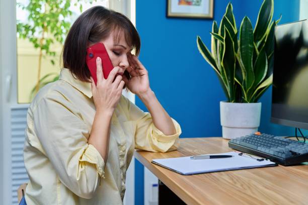 istock Sad middle aged woman talking on the phone 1424639775