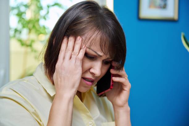 istock Sad middle aged woman talking on the phone 1424639788