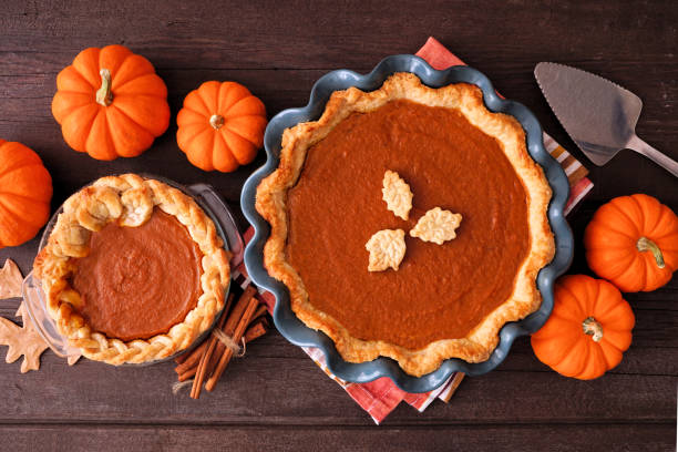 istock Homemade fall pumpkin pies. Table scene on dark wood. 1424644834