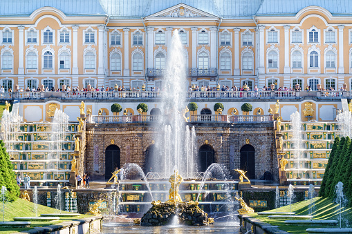 22 June 2022, Peterhof, Saint Petersburg, Russia. Grand Palace, Samson fountain and many tourists  in the lower park of Peterhof on a bright sunny day. Front view