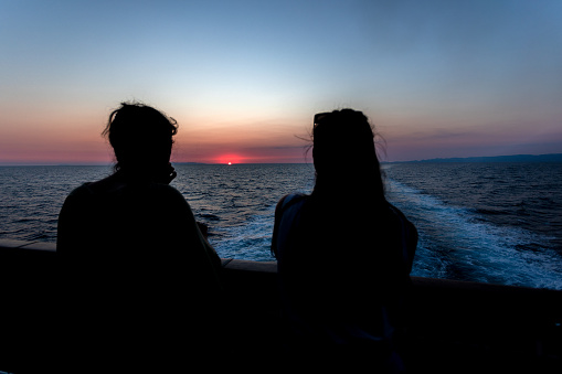 Couple sitting on the boat deck and enjoying the sunset