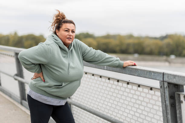 istock Obese Hispanic woman taking a break while exercising outside 1424650568