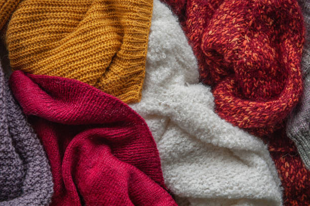 Autumn and winter background with knitted colourful sweaters Autumn and winter background with folded in stack of knitted colourful sweaters cardigan sweater stock pictures, royalty-free photos & images