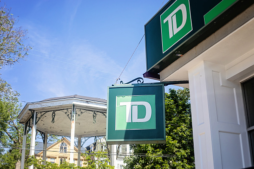 Lunenburg, Canada - August 29, 2022. Sign for the Toronto Dominion Bank in Lunenburg, beside the park with the heritage bandstand.