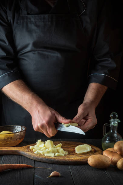 istock Before preparing the national dish, the chef cuts raw potatoes into small pieces with a knife. Close-up of a cook hands while working in a restaurant kitchen 1424659290