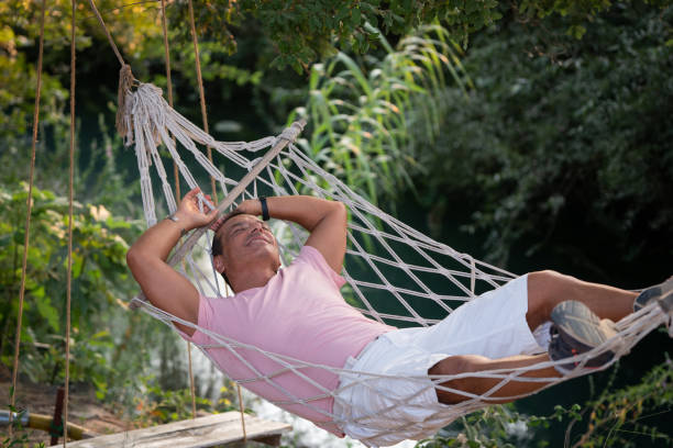 istock Man lying in hammock by the stream in the garden 1424662448