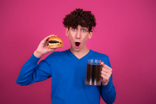 istock Diet and healthy lifestyle. Young attractive guy eats a burger. 1424664231
